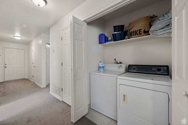 Laundry area with separate washer and dryer and light colored carpet | Image 32