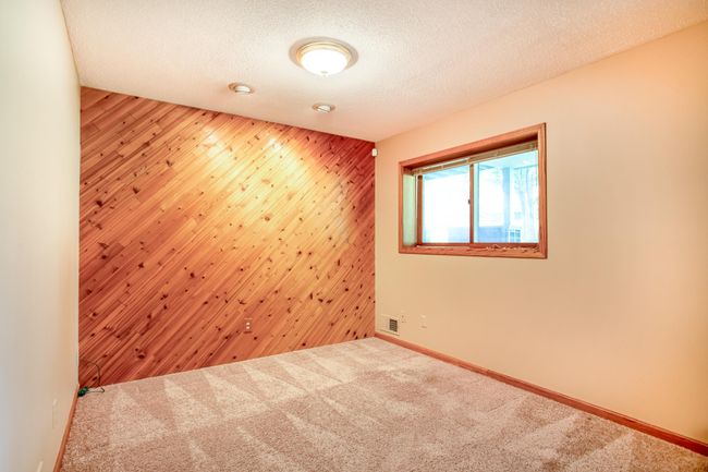 Cozy lower level den with warm pine accent wall, perfect as a home office or a 3rd bedroom addition.. | Image 25