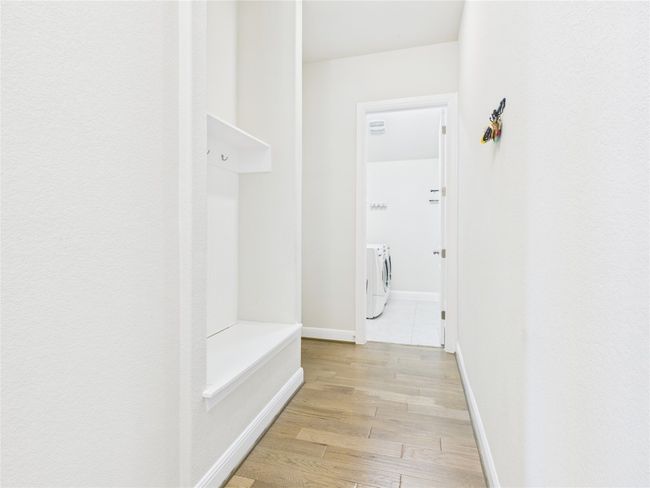 Hallway featuring baseboards, washer and clothes dryer, and light wood finished floors | Image 4