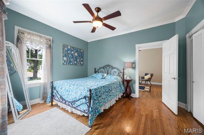 Bedroom featuring wood finished floors, crown molding, a closet, and ceiling fan | Image 16