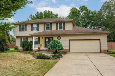 View of front facade featuring a front yard and a garage | Image 1