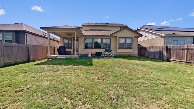 Backyard is fully fenced and backs to a green space. Also features a covered patio space with a ceiling fan and a cozy xeriscape fire pit area right beside it. | Image 27