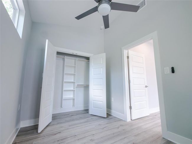 Unfurnished bedroom featuring wood finished floors, a closet, and a ceiling fan | Image 12