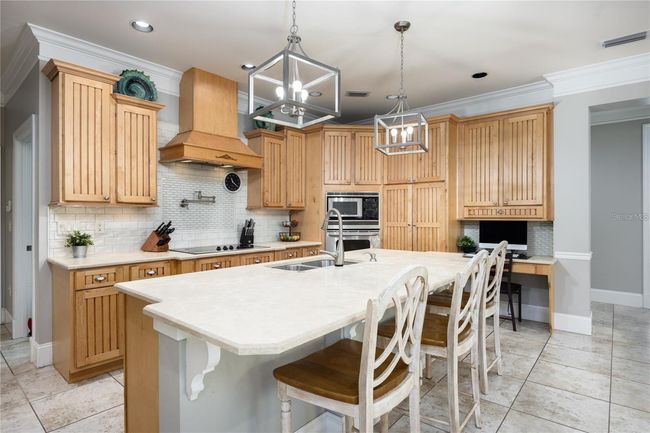 Fully upgraded kitchen with stainless steel appliances, custom cabinets, granite counters, large island with seating, and much more! | Image 8