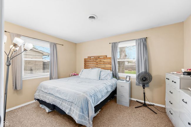 bedroom featuring light carpet, multiple windows, visible vents, and baseboards | Image 26