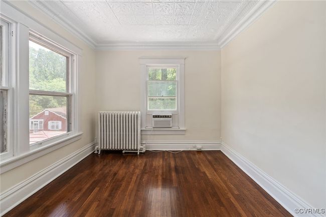 Bedroom featuring radiator, wood flooring, an ornate ceiling, cooling unit, and ornamental molding | Image 27