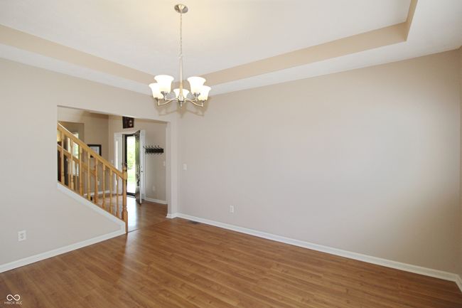 This flex space is located right off the entry and features tray ceilings and a fresh coat of neutral paint | Image 6