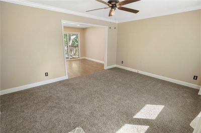 Spare room with ornamental molding, ceiling fan, and carpet flooring | Image 3