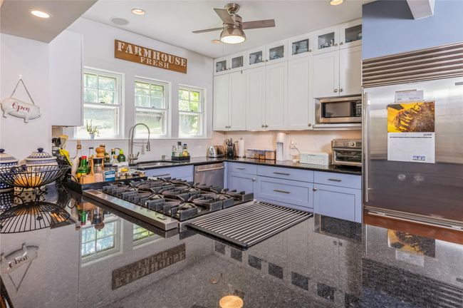 Top of the line stainless steel appliances, center island with ample counter space and abundant natural light make this a delightful space! | Image 12