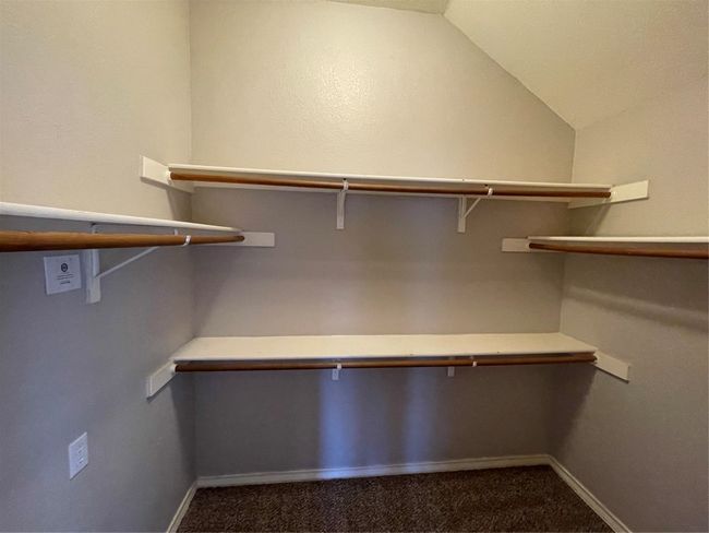 Walk in closet featuring dark carpet and vaulted ceiling | Image 29