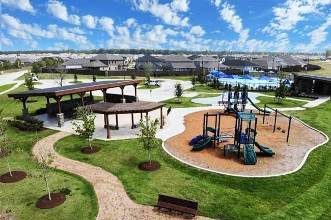 Surrounded by soft, well-maintained turf and shaded seating areas, it features colorful slides, climbing structures, swings, and interactive play zones designed for all ages. | Image 31