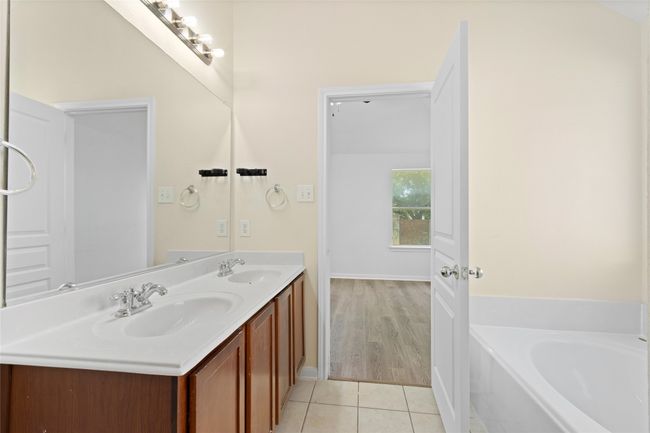 Full bathroom featuring double vanity, tile patterned flooring, and a bath | Image 18