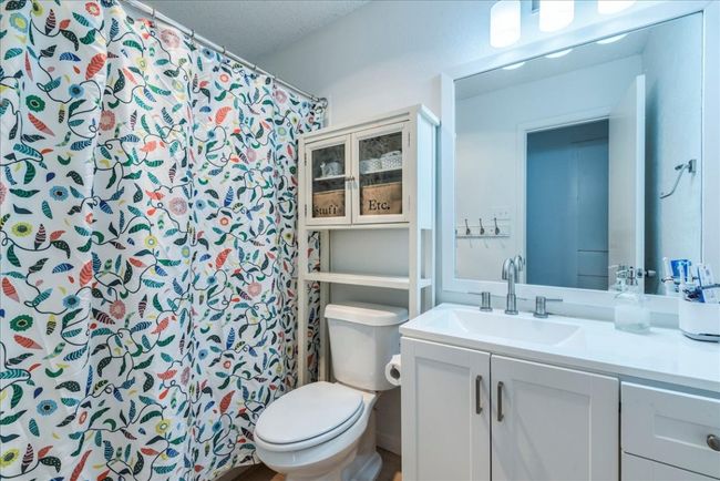 Full bath featuring curtained shower, toilet, vanity, and a textured ceiling | Image 18