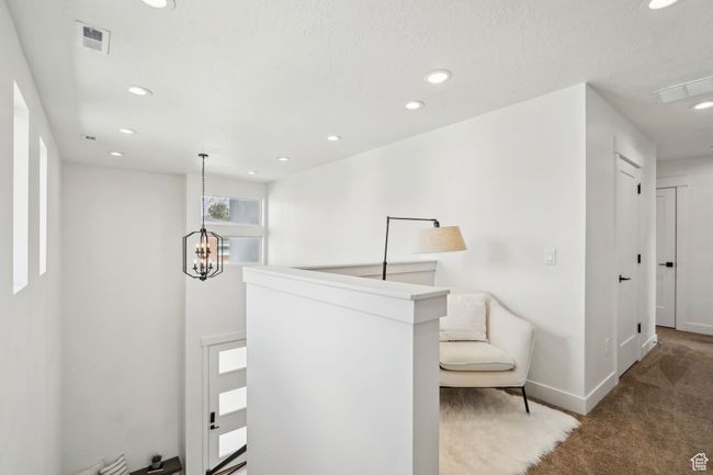Hall with carpet floors, baseboards, recessed lighting, and a notable chandelier | Image 14