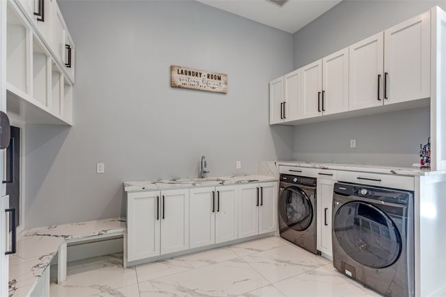 Laundry room with separate washer and dryer, cabinet space, and a sink | Image 24