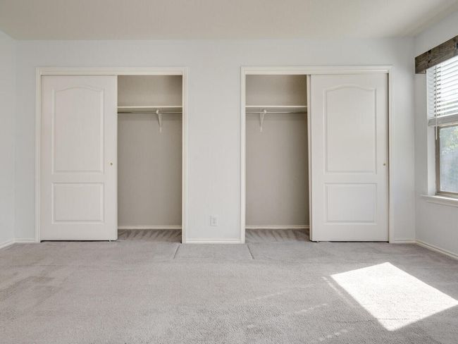 Primary bedroom featuring two closets, carpet floors, and a ceiling fan. | Image 16