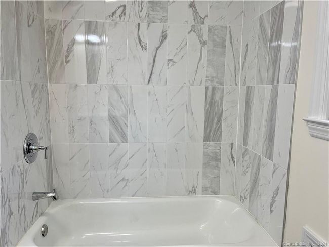 Beautifully tiled bathtub with shower. | Image 9