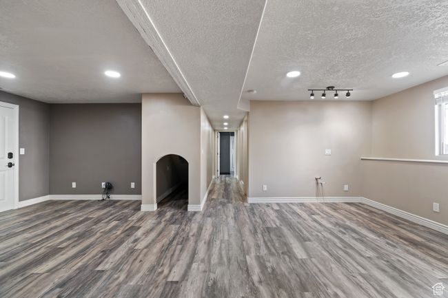 Basement with baseboards, recessed lighting, wood finished floors, and a textured ceiling | Image 32