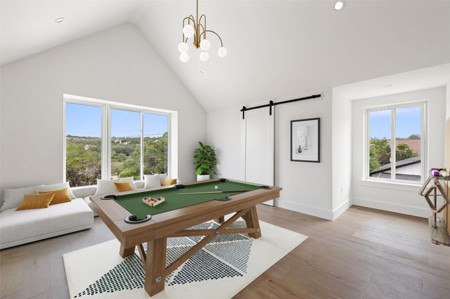 Rec room with plenty of natural light, high vaulted ceiling, a barn door, billiards, and light wood finished floors | Image 22