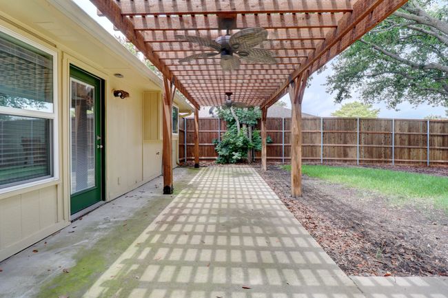 Fenced backyard with a ceiling fan, a pergola, and a patio | Image 25