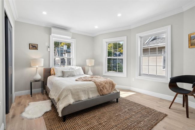 Bedroom with multiple windows, light wood-type flooring, crown molding, and recessed lighting | Image 5