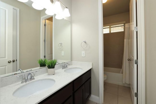 First full bath with double sinks and quartz counters. Tub/shower combo with additional door. | Image 10