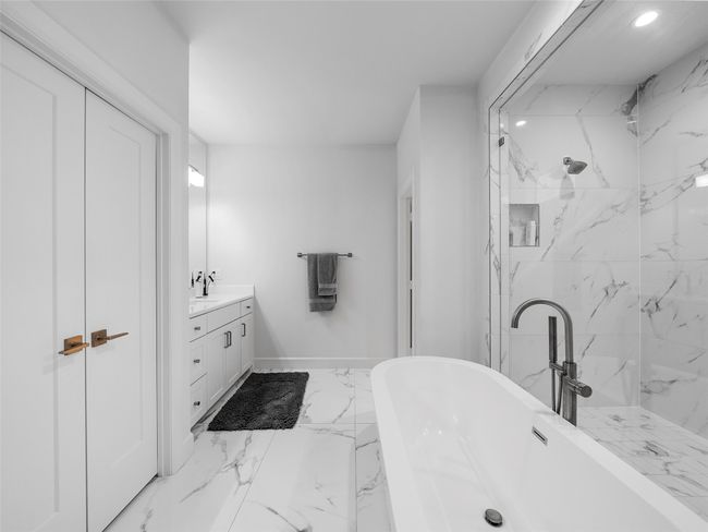 Full bathroom with marble look tiles, a freestanding bath, vanity, a marble finish shower, and recessed lighting | Image 26