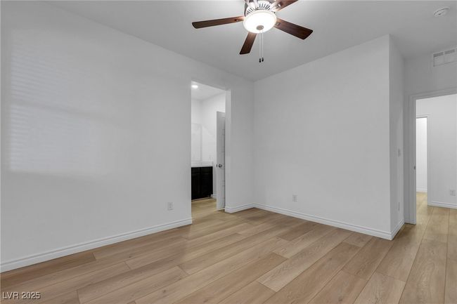Unfurnished room featuring light wood-type flooring, a ceiling fan, baseboards, and a smoke detector | Image 11