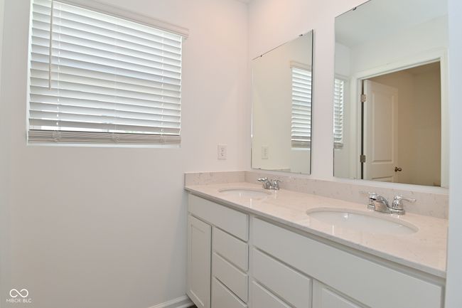 Hall way bath featuring double vanity and healthy amount of natural light | Image 41