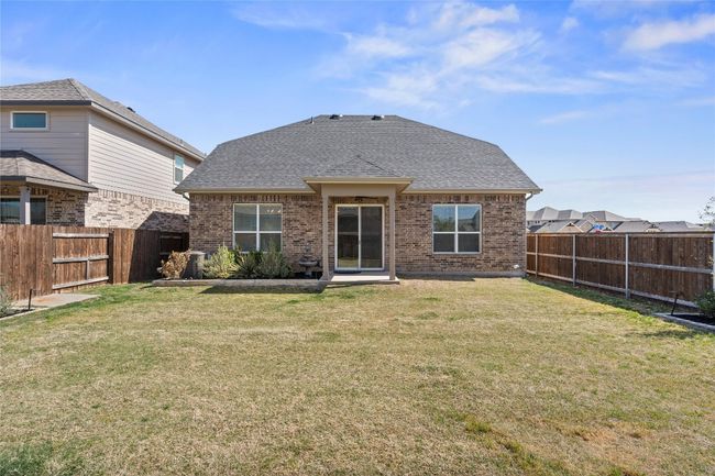 Back of property with brick siding, a fenced backyard, and a yard | Image 34