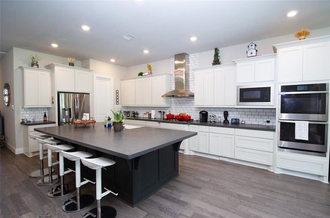 Kitchen with double ovens and gas range. | Image 9