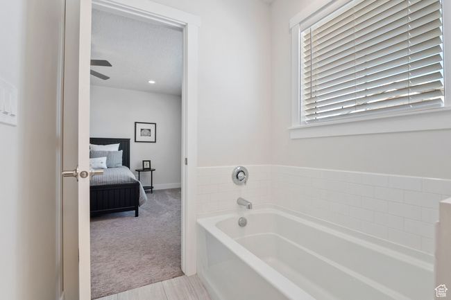 Bathroom with a bath, connected bathroom, plenty of natural light, and ceiling fan | Image 17
