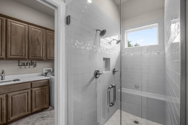 Primary bathroom with a large walk-in shower and pocket door to utility room | Image 18