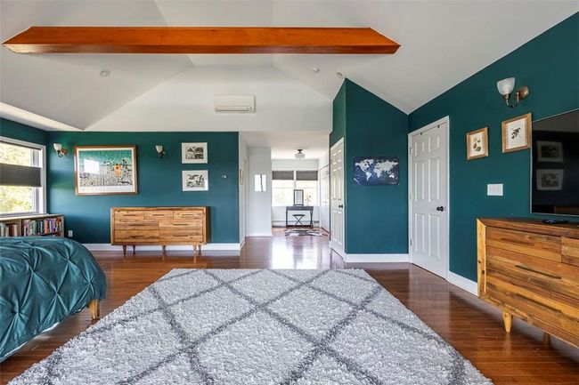Bedroom featuring beamed ceiling, dark hardwood / wood-style flooring, high vaulted ceiling, and a closet | Image 22
