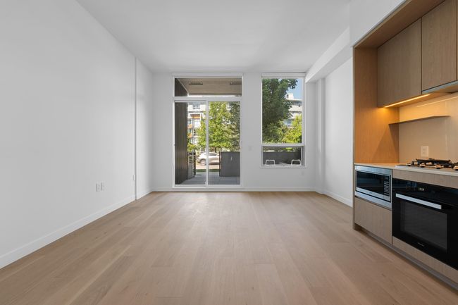 Kitchen featuring stainless steel appliances, light wood finished floors, light countertops, and modern cabinets | Image 9