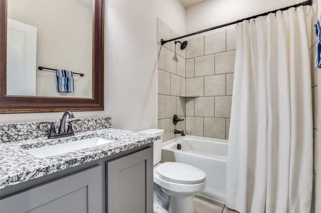 Bathroom featuring vanity, shower / tub combo with curtain, and a textured wall | Image 31