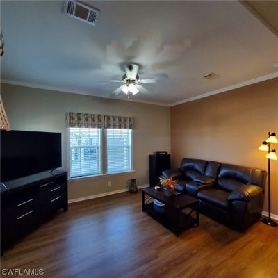 Spacious Living room with ceiling fan and laminate floor. | Image 3