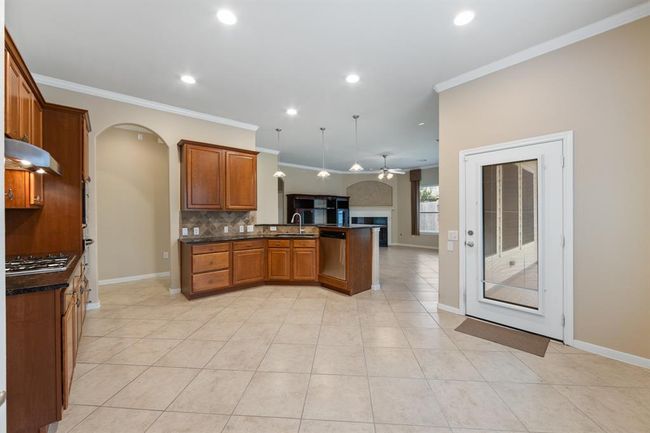 An exterior door directly from the kitchen area leads to a screened-in porch, offering a shaded retreat with views of the backyard | Image 22