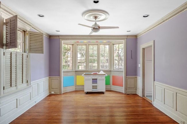 Spare room with a ceiling fan, a wainscoted wall, ornamental molding, wood finished floors, and a decorative wall | Image 11