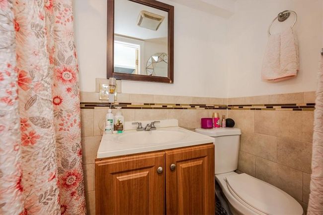 Bathroom with vanity, tile walls, and toilet | Image 15