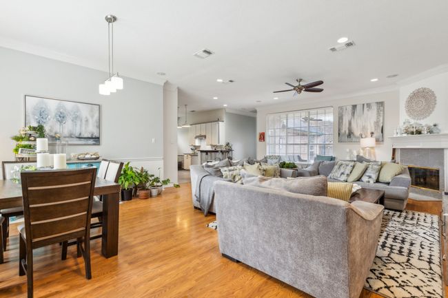Living room with crown molding, light wood-type flooring, visible vents, ceiling fan, and recessed lighting | Image 6