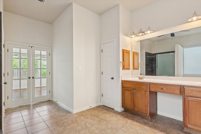 Bathroom with vanity, a shower, french doors, and tile patterned flooring | Image 20