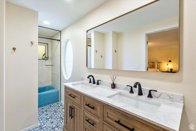 Full bathroom featuring double vanity, bathing tub / shower combination, and tile patterned floors | Image 36
