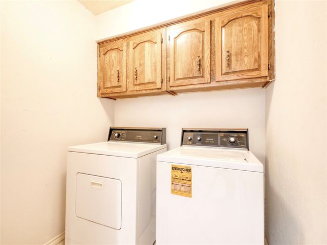 Laundry room featuring washing machine, clothes dryer and cabinet space | Image 25