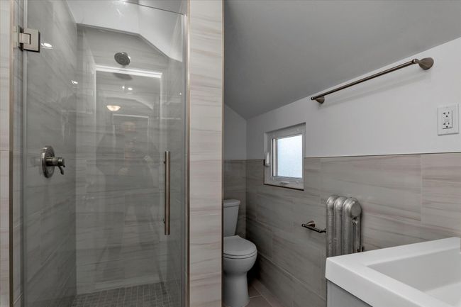 Bathroom featuring toilet, tile walls, and walk in shower | Image 12