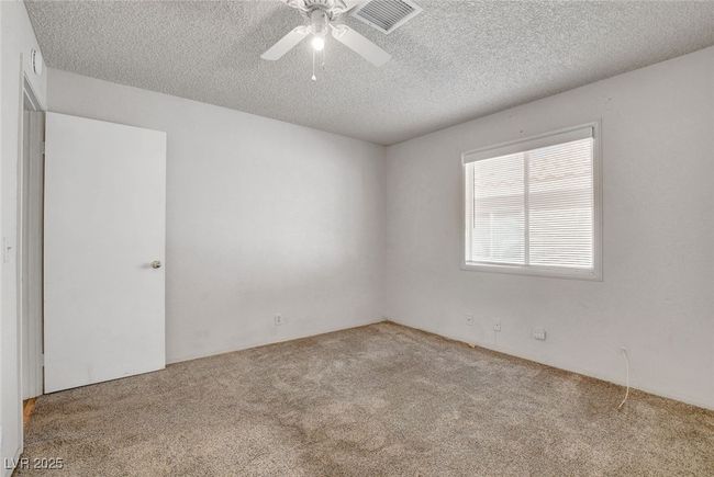 Unfurnished room featuring a textured ceiling, ceiling fan, visible vents, and carpet floors | Image 21