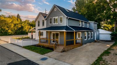 View of front of property featuring an outdoor structure, a garage, and covered porch | Image 1