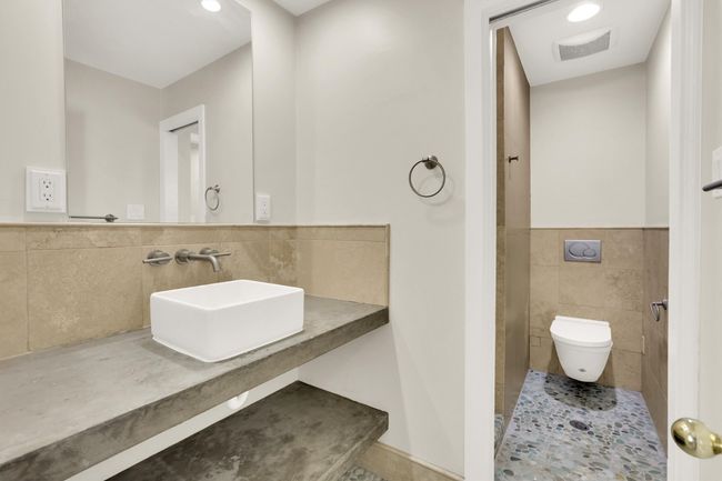 Full bath featuring a wainscoted wall, toilet, tile walls, visible vents, and a shower | Image 27