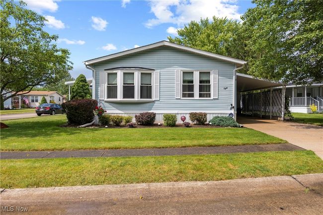 Manufactured / mobile home with concrete driveway, a front yard, and a carport | Image 10