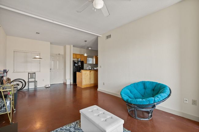 Sitting room with a ceiling fan, concrete floors, and baseboards | Image 14